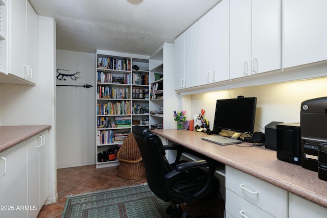 office featuring a textured ceiling and dark tile patterned flooring