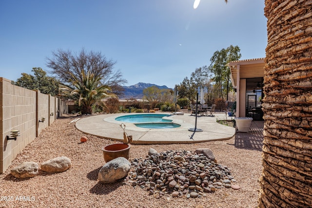 outdoor pool featuring a patio area, a mountain view, and a fenced backyard