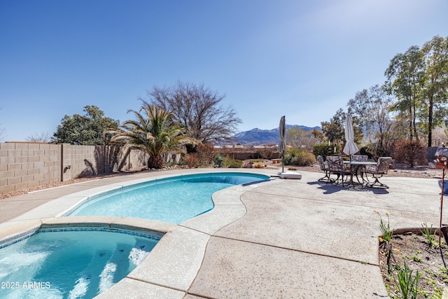 view of pool with a fenced in pool, a patio area, a mountain view, fence, and an in ground hot tub