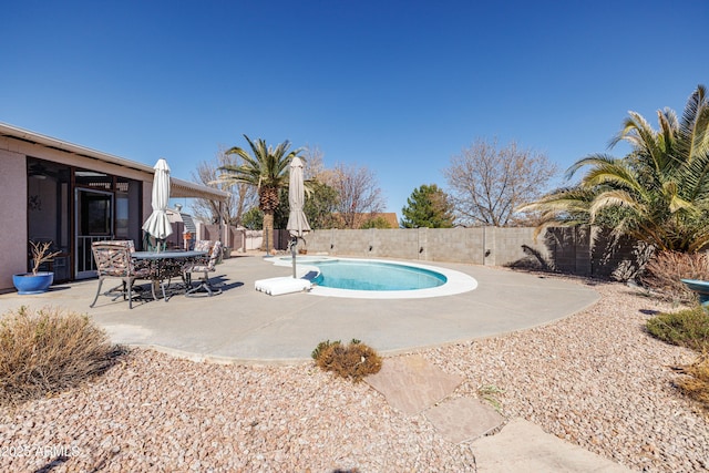 view of swimming pool with a fenced in pool, a fenced backyard, and a patio