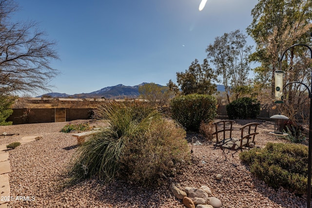 view of yard featuring fence and a mountain view