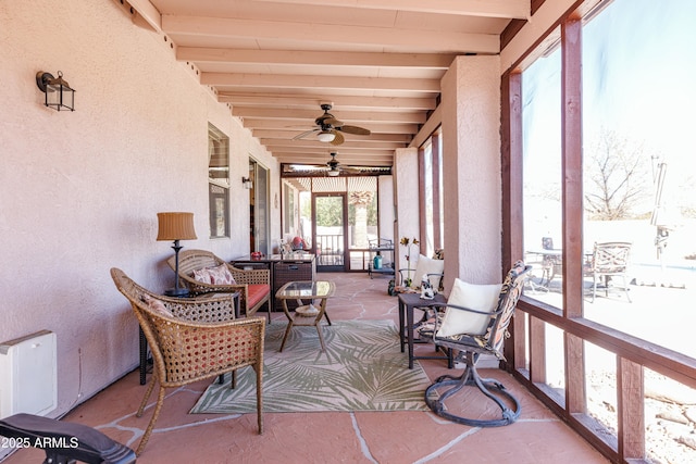 sunroom / solarium with ceiling fan and beam ceiling