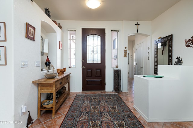 foyer entrance featuring arched walkways and tile patterned flooring