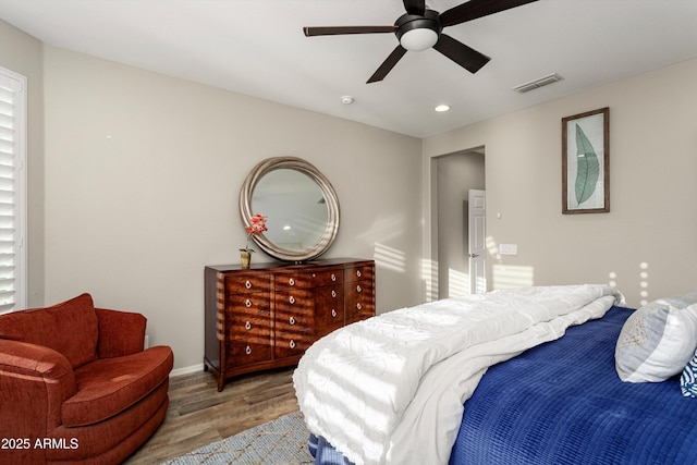 bedroom featuring a ceiling fan, wood finished floors, visible vents, baseboards, and recessed lighting