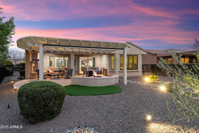 back of property at dusk featuring stucco siding, a pergola, a patio, a fenced backyard, and outdoor lounge area