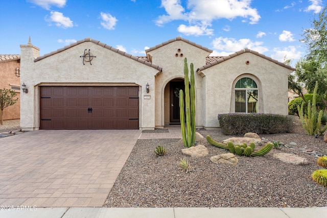 mediterranean / spanish house featuring stucco siding, driveway, and an attached garage