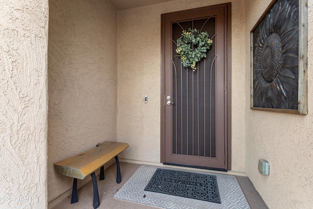 doorway to property featuring stucco siding