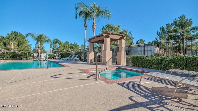 view of swimming pool with a patio area and a hot tub