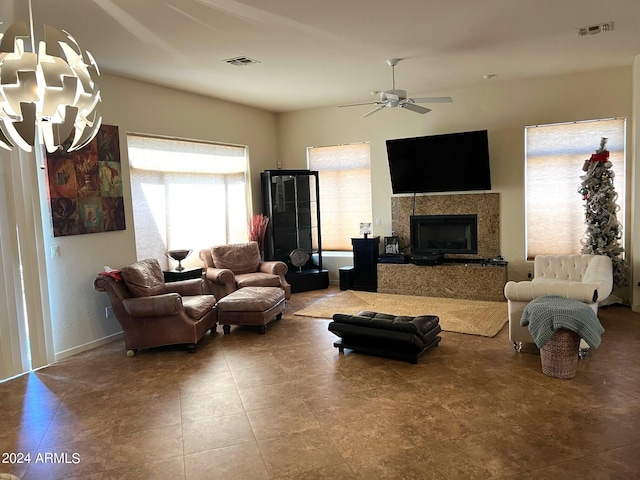 living room with ceiling fan and a tile fireplace