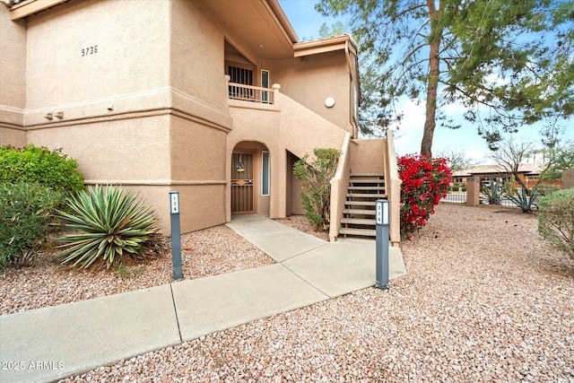 exterior space featuring a gate, fence, and stucco siding