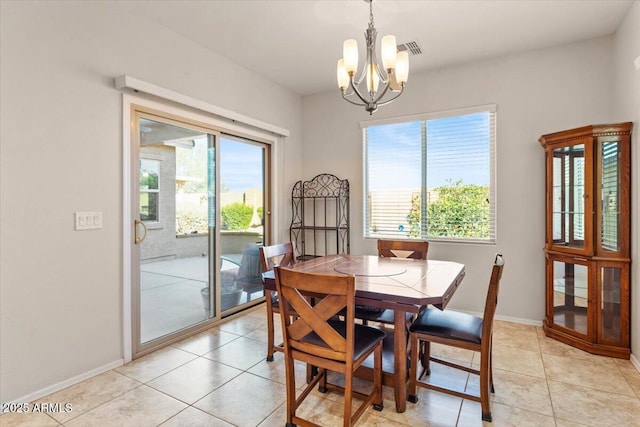 dining space featuring light tile patterned floors and a chandelier