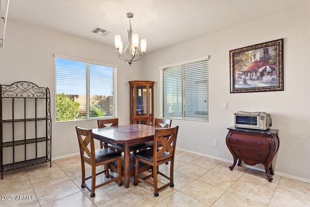 tiled dining area featuring a chandelier