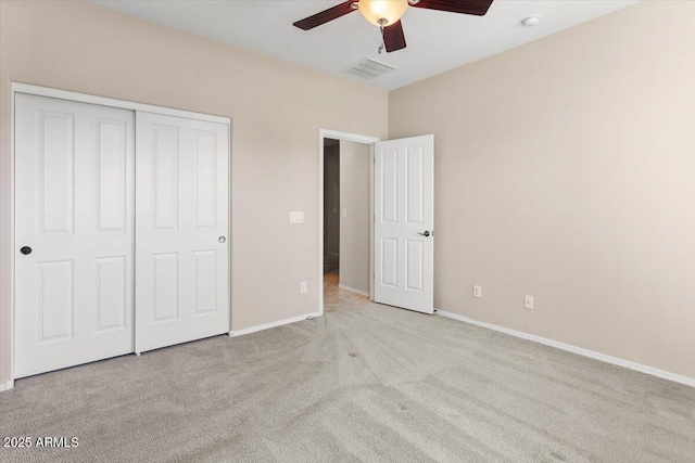 unfurnished bedroom with ceiling fan, a closet, and light carpet