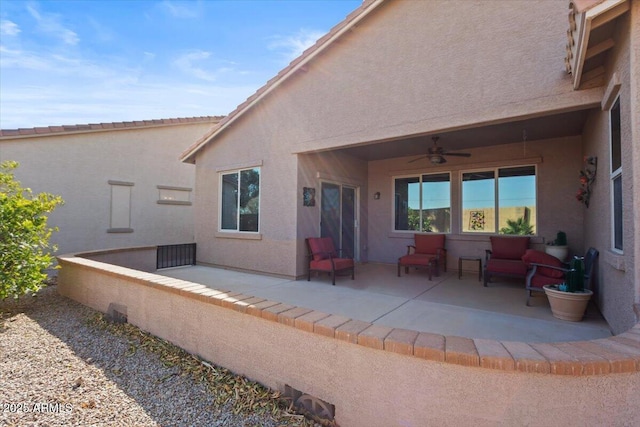 back of property with ceiling fan and a patio