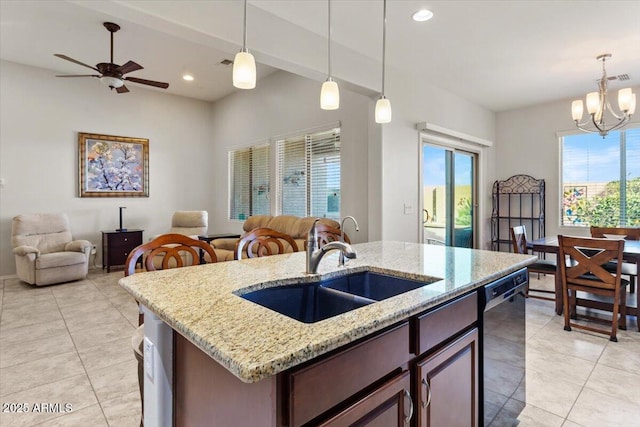 kitchen with decorative light fixtures, an island with sink, black dishwasher, sink, and light stone counters