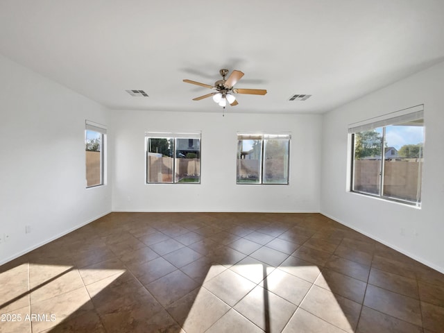 unfurnished room with ceiling fan and dark tile patterned floors