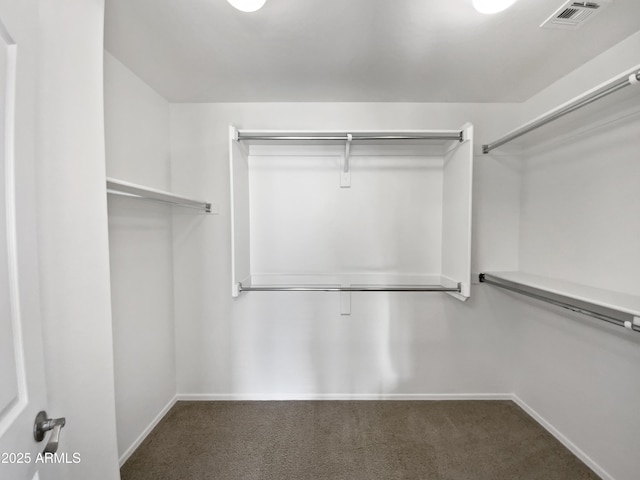 walk in closet featuring dark colored carpet