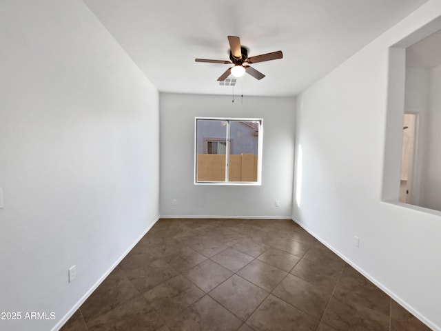 tiled spare room featuring ceiling fan