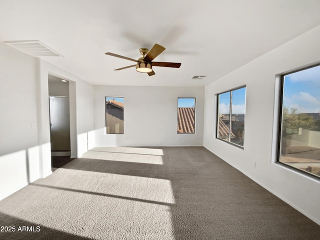 unfurnished room featuring ceiling fan and dark carpet