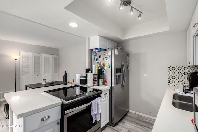 2514 N 22nd Ave, Phoenix, AZ 85009 - kitchen featuring appliances with stainless steel finishes, light wood finished floors, baseboards, a peninsula, and light countertops