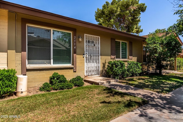 2514 N 22nd Ave, Phoenix, AZ 85009 - doorway to property featuring a yard, concrete block siding, and brick siding