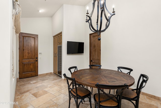 dining area featuring a notable chandelier, vaulted ceiling, and light tile floors