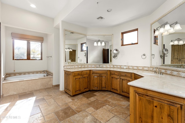 bathroom featuring tiled bath, dual bowl vanity, and tile flooring