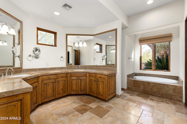 bathroom with an inviting chandelier, tile flooring, a relaxing tiled bath, and double vanity