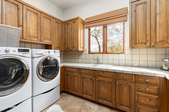 laundry room with cabinets, independent washer and dryer, sink, and light tile floors