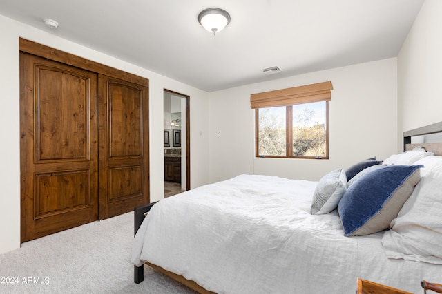 bedroom featuring light carpet and ensuite bath