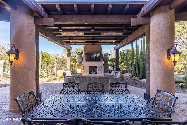 view of terrace with an outdoor living space with a fireplace