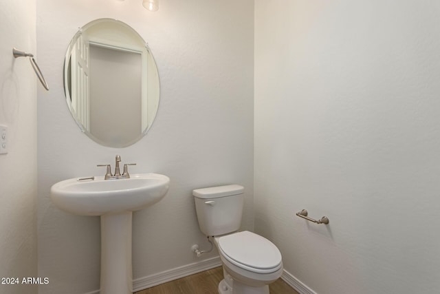 bathroom with hardwood / wood-style flooring, sink, and toilet