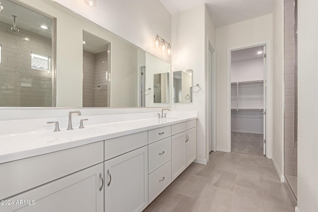 bathroom with tiled shower and vanity