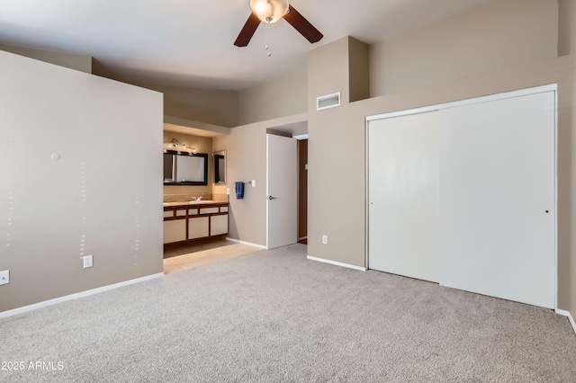 unfurnished living room with light carpet, ceiling fan, sink, and high vaulted ceiling