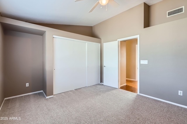 unfurnished bedroom featuring vaulted ceiling, ceiling fan, carpet, and a closet