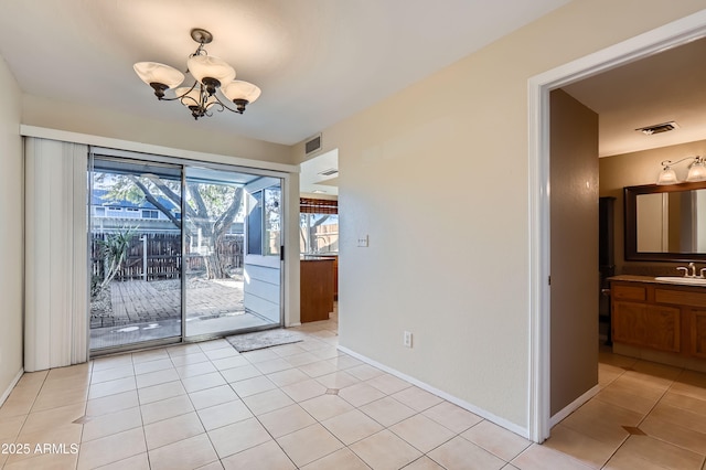 interior space featuring light tile patterned flooring, a chandelier, and sink