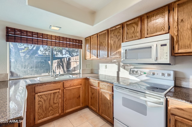 kitchen featuring sink, white appliances, and light tile patterned flooring