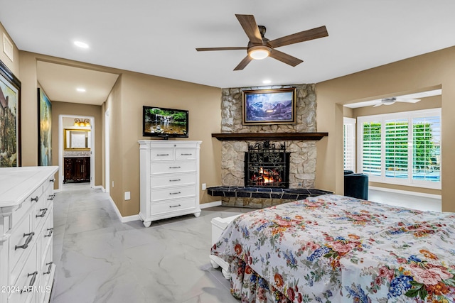 bedroom featuring a fireplace, ensuite bath, and ceiling fan