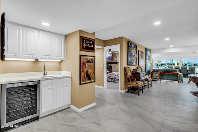 bar with white cabinetry, sink, and wine cooler