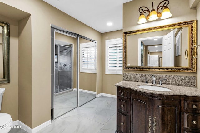 bathroom featuring vanity, toilet, and a shower with shower door