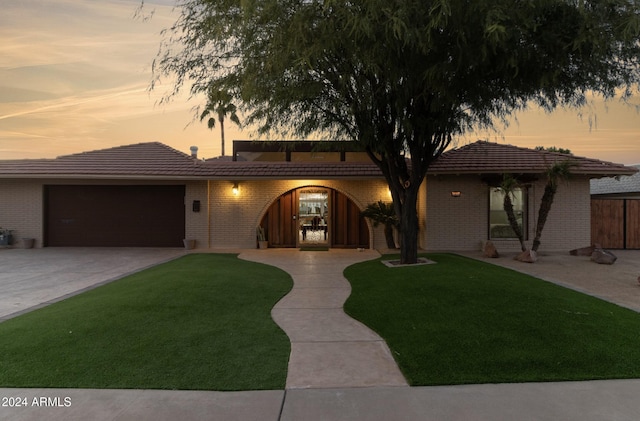 view of front of home with a lawn and a garage