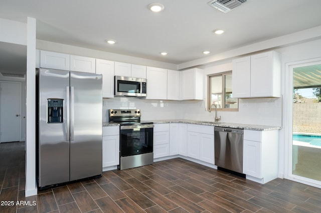 kitchen with sink, white cabinets, and stainless steel appliances