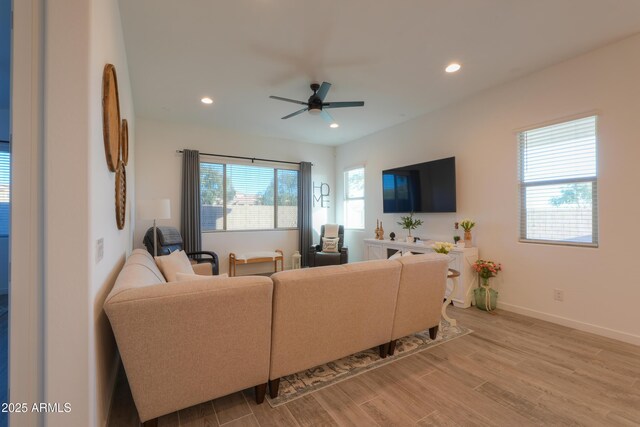 living room with ceiling fan, light hardwood / wood-style floors, and plenty of natural light