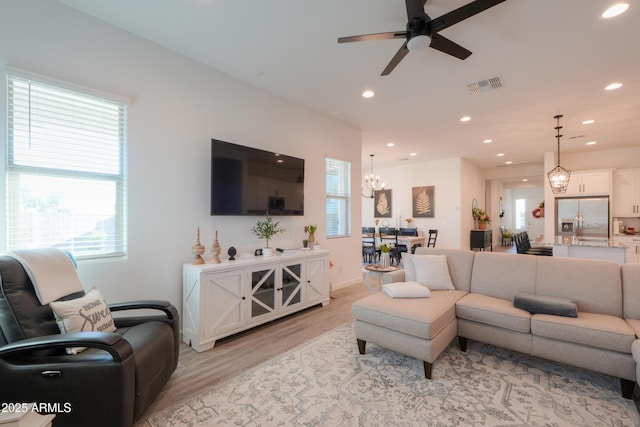 living room featuring ceiling fan, light hardwood / wood-style flooring, and a wealth of natural light