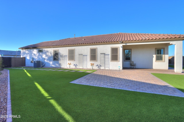 rear view of house with central AC, a patio area, and a yard