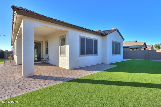 back of house featuring a patio and a yard