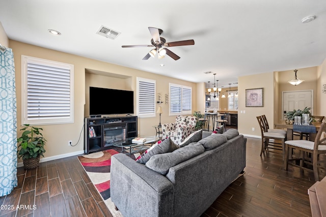 living area with baseboards, visible vents, ceiling fan with notable chandelier, wood finish floors, and recessed lighting