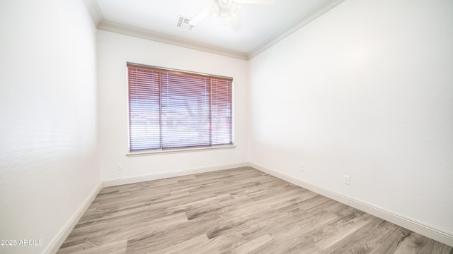 spare room with light wood-style flooring, visible vents, baseboards, and ornamental molding