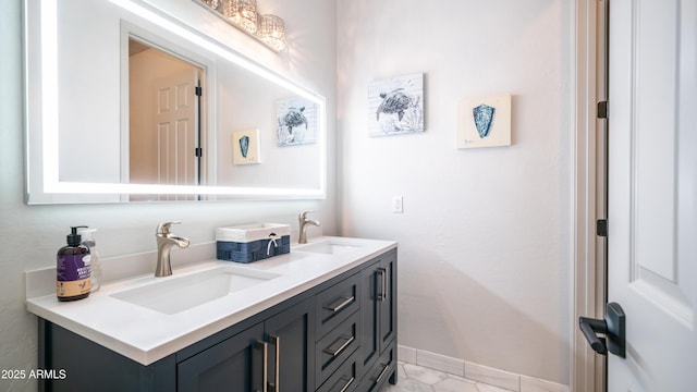 bathroom with double vanity, baseboards, and a sink