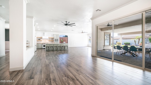 living area featuring ornamental molding, visible vents, plenty of natural light, and wood finished floors